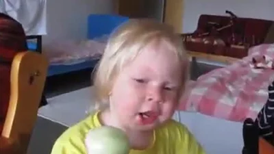 Маленька дівчинка їсть цибулю як яблуко