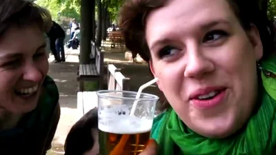 Странная девушка пьет пиво через ухо