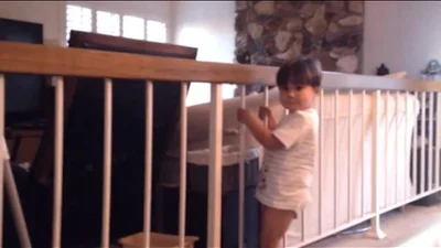 Маленькая девочка идет по обрыву балкона