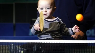 Двухлетний ребенок круто играет в теннис
