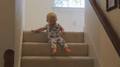 Бесподобный ребенок спускается попкой по лестнице