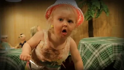 Смешная девочка жадно объедает своих кукол