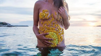 Чувственная и прекрасная фотосессия беременной с животиком, покрытым цветами