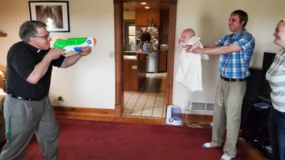 Гениально: священники придумали лайфхак и крестят детей из игрушечных пистолетов