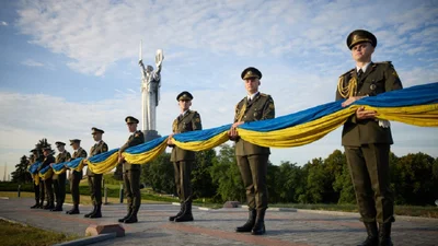 Фото дня: у Києві підняли прапор, підписаний бійцями ЗСУ