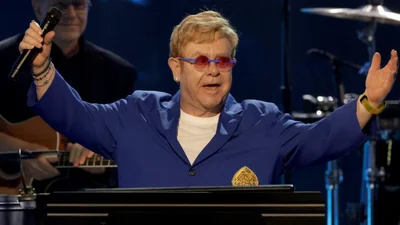 Епатаж року: Елтон Джон перетворив власні коліна на золоте намисто - фото